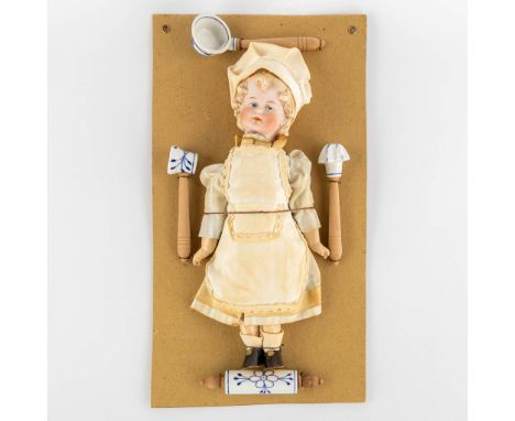 William Goebel, 'Boy Chef' a porcelain doll mounted on a cardboard with accessories.On the reverse marked G.W. with a crown. 