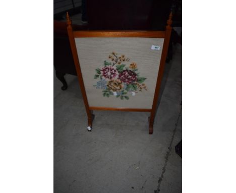 A traditional stained frame fire screen having woolwork insert