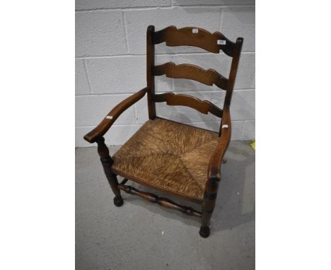 A nursing chair having oak frame with rush seat and ladder back