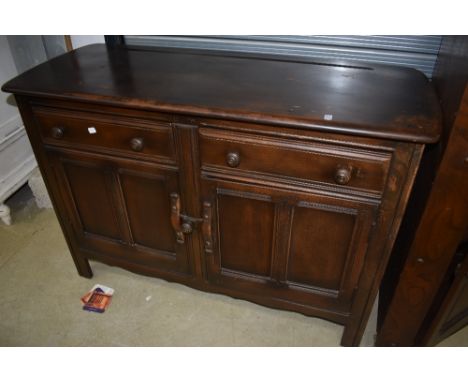 A dark stained Ercol sideboard, along with an Ercol double corner cupboard, the sideboard without label, the corner cupboard 