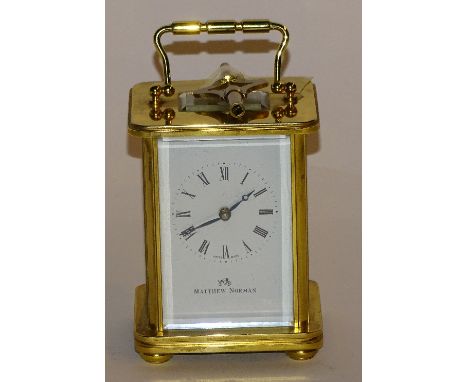 A Swiss made gilt metal cased carriage clock signed Matthew Norman, the white enamel dial with Roman numerals, with key, 11cm