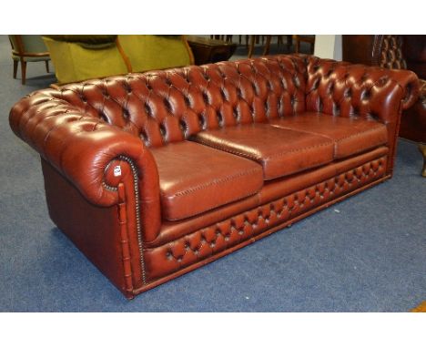 A Chesterfield ox blood leather three seater sofa, with rolled arm rests, 61cm high x 193cm wide CONDITION REPORT: Lot 450 - 