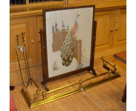 A brass fire fender, 22cm high x 133cm wide, together with two brass fireirons, tongs and poker, and a mahogany firescreen de