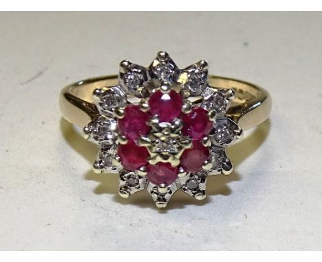 A 9ct gold moissanite and ruby dress ring, set in layered flowerhead formation, stamped 375, ring size O, 3.3g