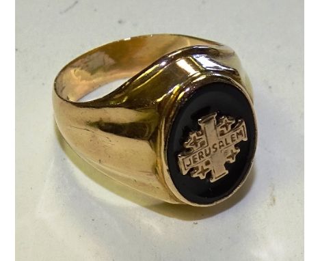 A gentleman's 18ct gold ring, with crucifix to centre marked 'Jerusalem' on black enamel round, stamped 18, ring size W, 7.6g