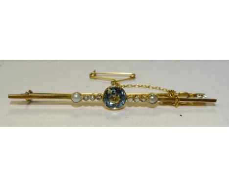 A yellow metal aquamarine and seed pearl brooch, the central round cut aquamarine measuring 7mm diameter, flanked by seed pea