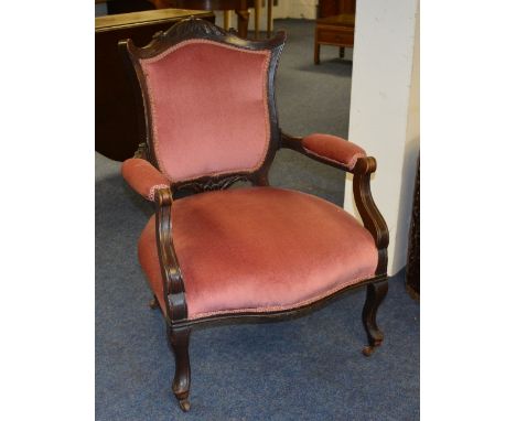An Edwardian mahogany parlour armchair, upholstered in later pink velour, raised on shaped supports with ceramic castors, 87.