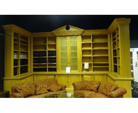 A large bespoke light oak bookcase, with open sections enclosing shelves above panelled doors, 312cm high x 718cm wide (acros