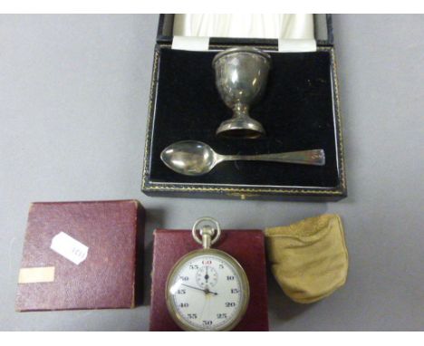 A vintage plated stop watch stamped to back with crown  A M 6B/117 2455/40 and a cased silver plated egg cup and spoon 