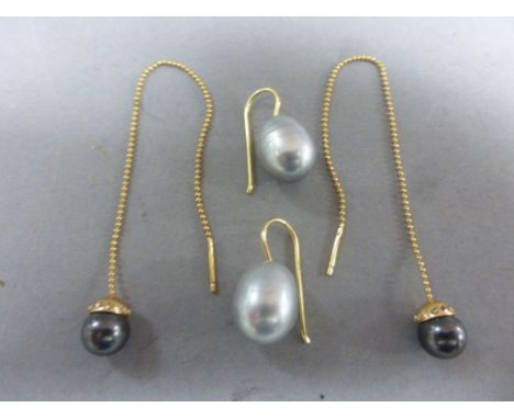 A pair of grey pearl earrings and one other  pair mounted on yellow metal chains 