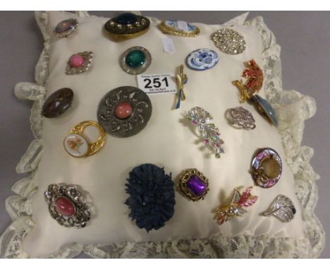 Group of decorative brooches including Celtic on a plush cushion