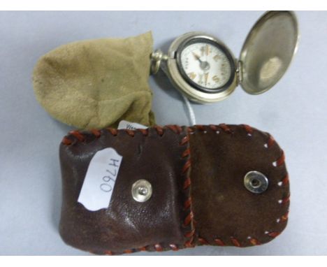 A steel cased compass in a leather pouch
