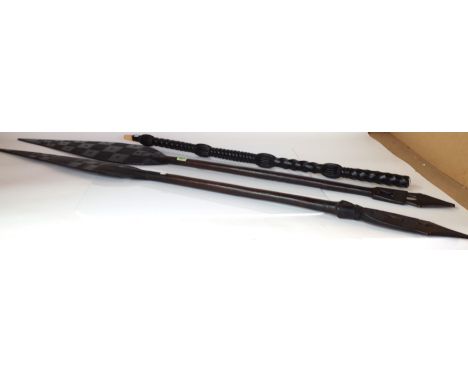 TWO MID-20TH CENTURY TRIBAL PADDLES (3)Each 145cm long and a hardwood walking stick with turned decoration 94cm long