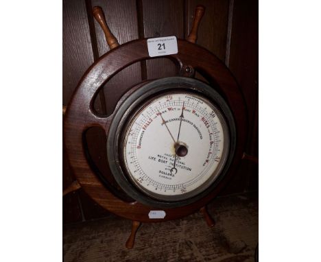 A fisherman's aneroid barometer by Dolland, mounted on ships wheel 