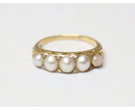A Victorian ring set row of five graduated split pearls with pairs of tiny rose diamonds in between, to an un-marked yellow m
