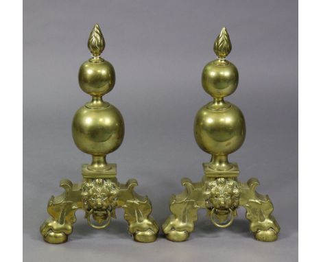 A pair of Victorian large brass andirons, with flame finials on bulbous supports, claw-&amp;-ball front feet centred by a lio
