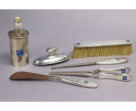 A Liberty &amp; Co. “Cymric” silver part dressing table set with coloured enamel Celtic motifs, comprising a silver-coated gl