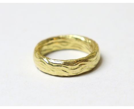 An 18ct yellow gold band, the textured surface with wave design, size M/N, 10g.