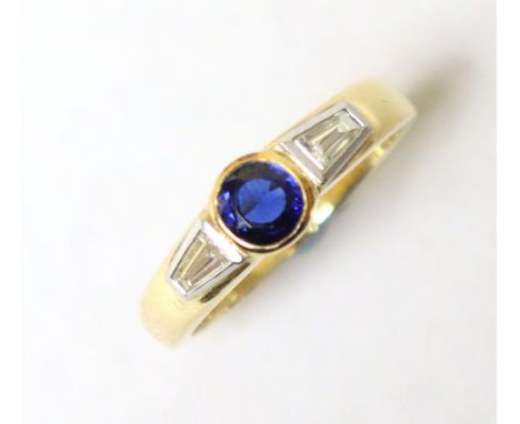 A sapphire &amp; diamond ring, the oval-cut sapphire set between two baguettes, to an 18ct yellow gold shank, size R/S, 6.7g.