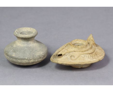 A Roman clay oil lamp with carved decoration, 3½” long, &amp; a similar squat globular vessel with flared rim, 2” high.