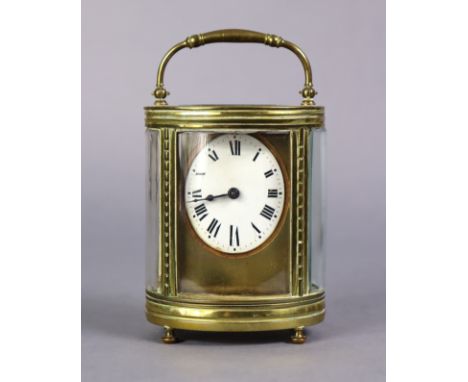 A late 19th century carriage clock in oval brass glazed case, the 1¾” oval white enamel dial with Roman numerals, with swing 
