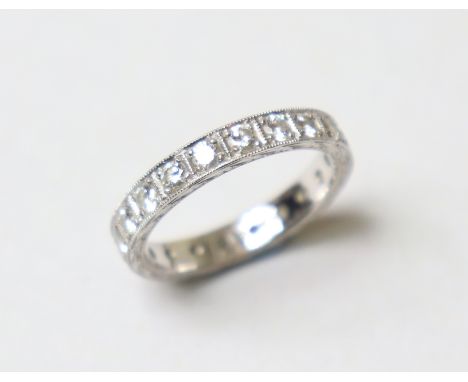 A diamond eternity ring, the engraved platinum band set twenty round-cut stones; Size: R; weight: 6.1g.