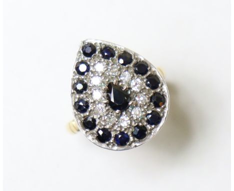 A sapphire &amp; diamond ring, the pear-shaped panel set concentric rows of small round-cut stones, a pear-shaped sapphire to