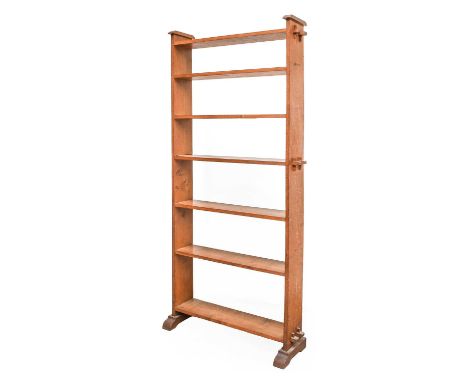 An Arts &amp; Crafts Oak Open Pegged Bookcase, the shaped ends with pegged construction, seven fixed shelves, on sledge feet,