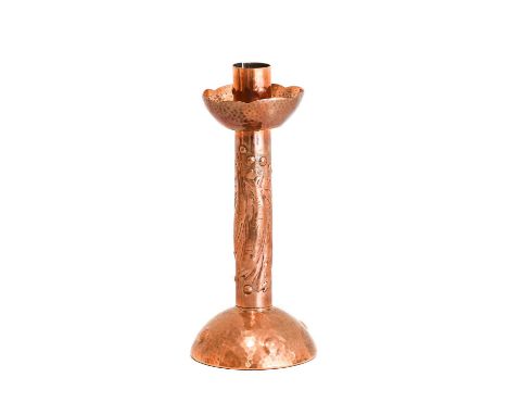 An Arts &amp; Crafts Newlyn Copper Candlestick, repoussé decorated with three fish and bubbles, riveted seam, on a planished 