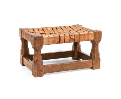 Workshop of Robert Mouseman Thompson (Kilburn): An English Oak Footstool, woven leather top, on four octagonal legs joined by