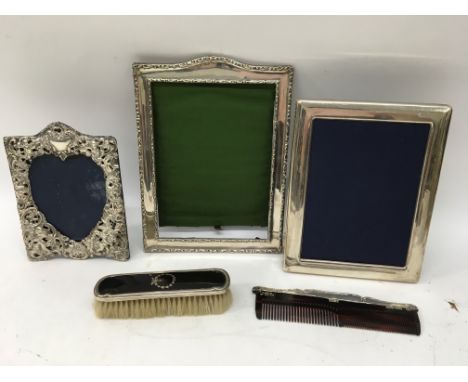 Three silver picture frames together with a brush and comb.