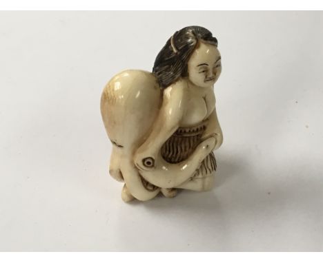 An interesting Japanese carved Ivory Netsuke, possible of the Meiji Period in the form of a Maori type figure, with an Octopu