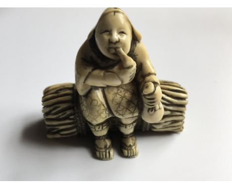 A Japanese carved Ivory Netsuke of the Meiji period 19th Century. In the form of a seated elder on abound bundle of wood sign