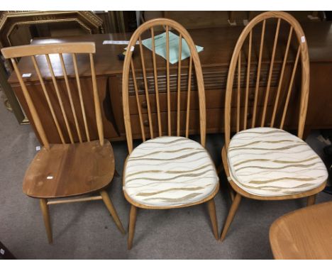An Ercol table and 2 sets of 4 chairs together with a sideboard.