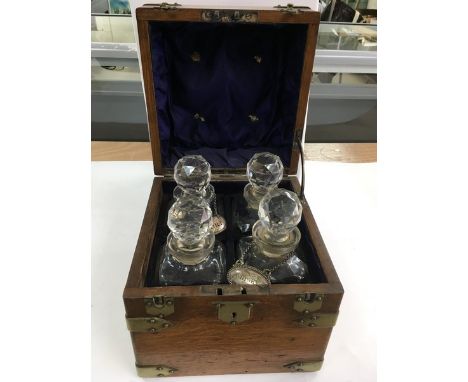 A brass bound wooden ship's decanter set, the fitted interior containing a set of four decanters, two with wine labels.Approx
