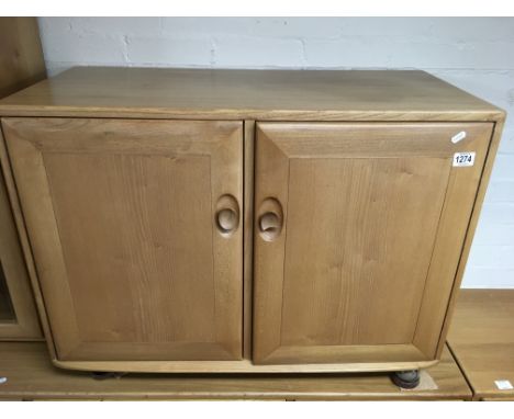 A light elm Ercol cupboard fitted with shallow drawers and record rack Approximately 90x60cm