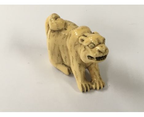 A Japanese carved Ivory Netsuke in the form of a Tiger possible late Meiji period 4cm.