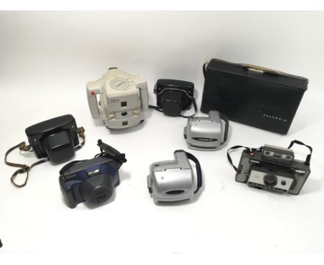 A collection of Polaroid cameras, including an early Macro and a 320.