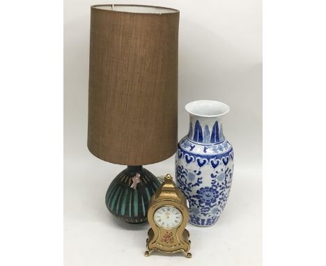 A Swiss pottery lamp, a blue and white baluster vase and a clock (3).