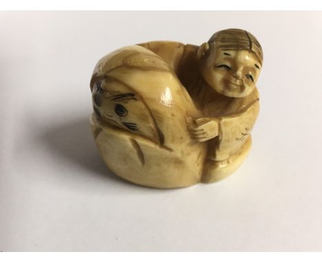 A Japanese carved Netsuke in the form of a child with a bear type figure,