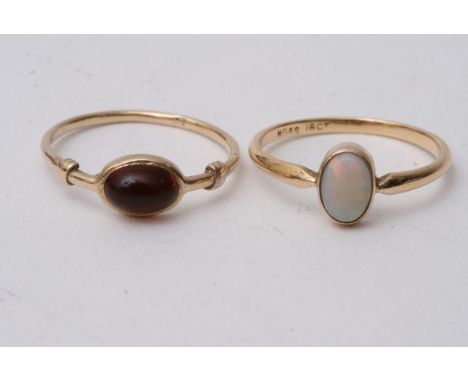 Two gold rings, one set with opal the other set with a red stone, sizes M-N.Total approx weight 2.8g.