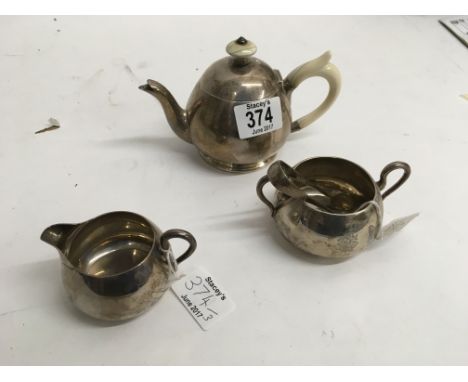 A three piece silver Victorian bachelors tea set, teapot with ivory handle. London hallmarks 1873