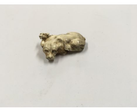 A Japanese carved Ivory Netsuke in the form of a dog with a puppy, possibly late Meiji period. Signed base 5cm.