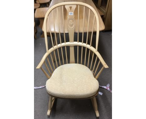 An Ercol light elm rocking chair with original cushion