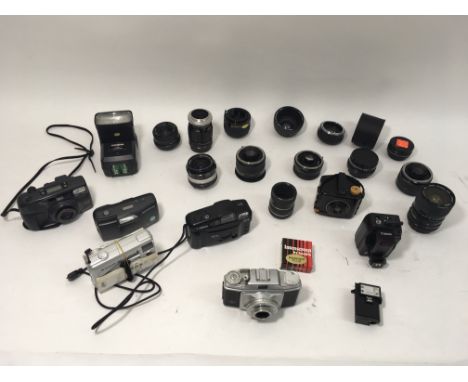 A mix of SLR film lenses, teleconverters, a Canon wireless receiver and various instamatic film cameras, plus an Agfa Rapid f