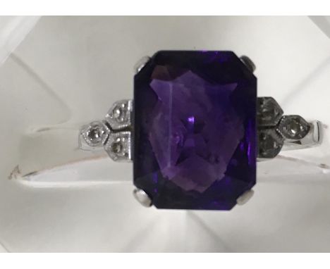 A fine Art Deco platinum and 18ct white gold ring set with facet cut square amethyst type stone, flanked by small diamonds.Ap