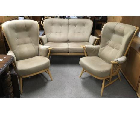 A light elm Ercol Windsor suite comprising a two seater sofa and two highback chairs