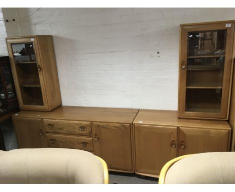 A light elm Ercol three drawer sideboard plus a smaller cupboard cabinet base and a pair of narrow display cabinets.Approxima