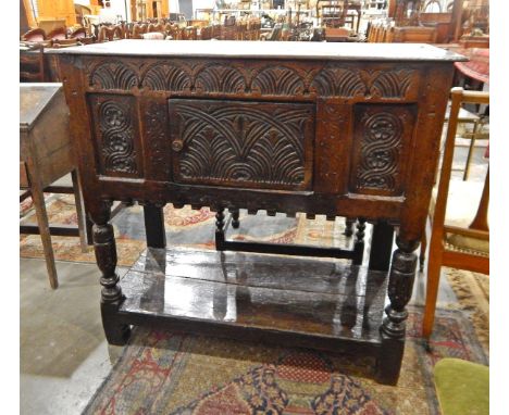 Antique carved oak cupboard on stand with floral carved panels, lunette frieze, on carved cup and cover supports with under-s