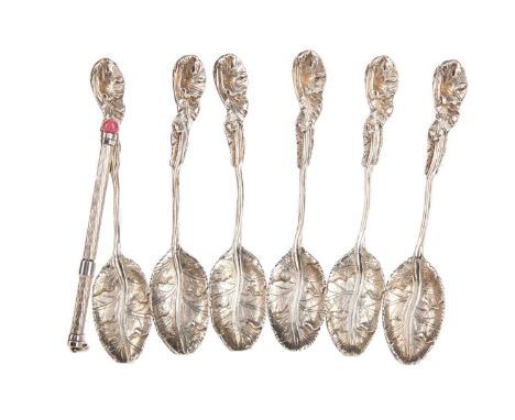 SET OF SIX WHITE METAL FOLIATE CAST TEASPOONS,unmarked, along with a silver swizzle stick